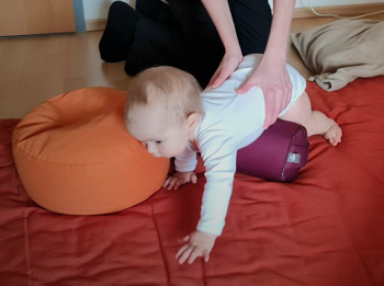 Shiatsu Behandlung für Baby am Rücken auf der Rolle liegend