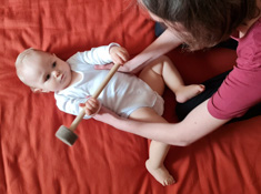 Shiatsu Behandlung für Baby am seitlichen Rumpf am Rückend liegend