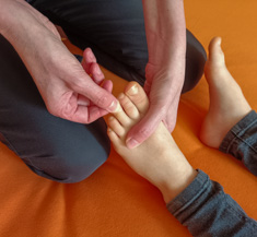 Shiatsu Behandlung für Kind an den Zehen