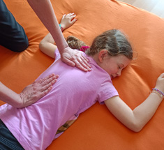 Shiatsu Behandlung für Kind am Rücken entlang der Wirbelsäule