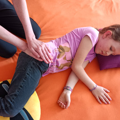 Shiatsu Behandlung für Kind an der Hüfte in Seitenlage